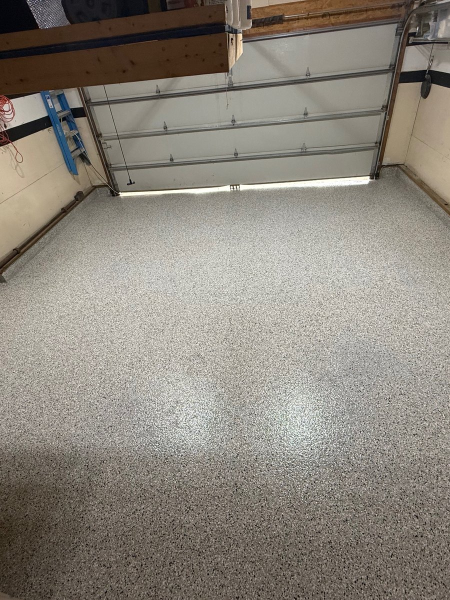 Gray, black and white flake epoxy garage floor after coating, seen from the doorway