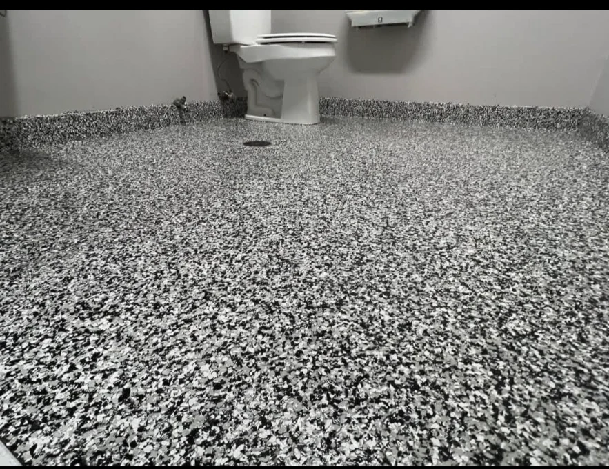 Black, gray and white flake floor in a commercial washroom