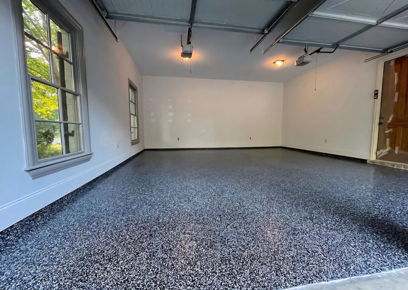 Finished charcoal flake epoxy floor in a bright residential garage