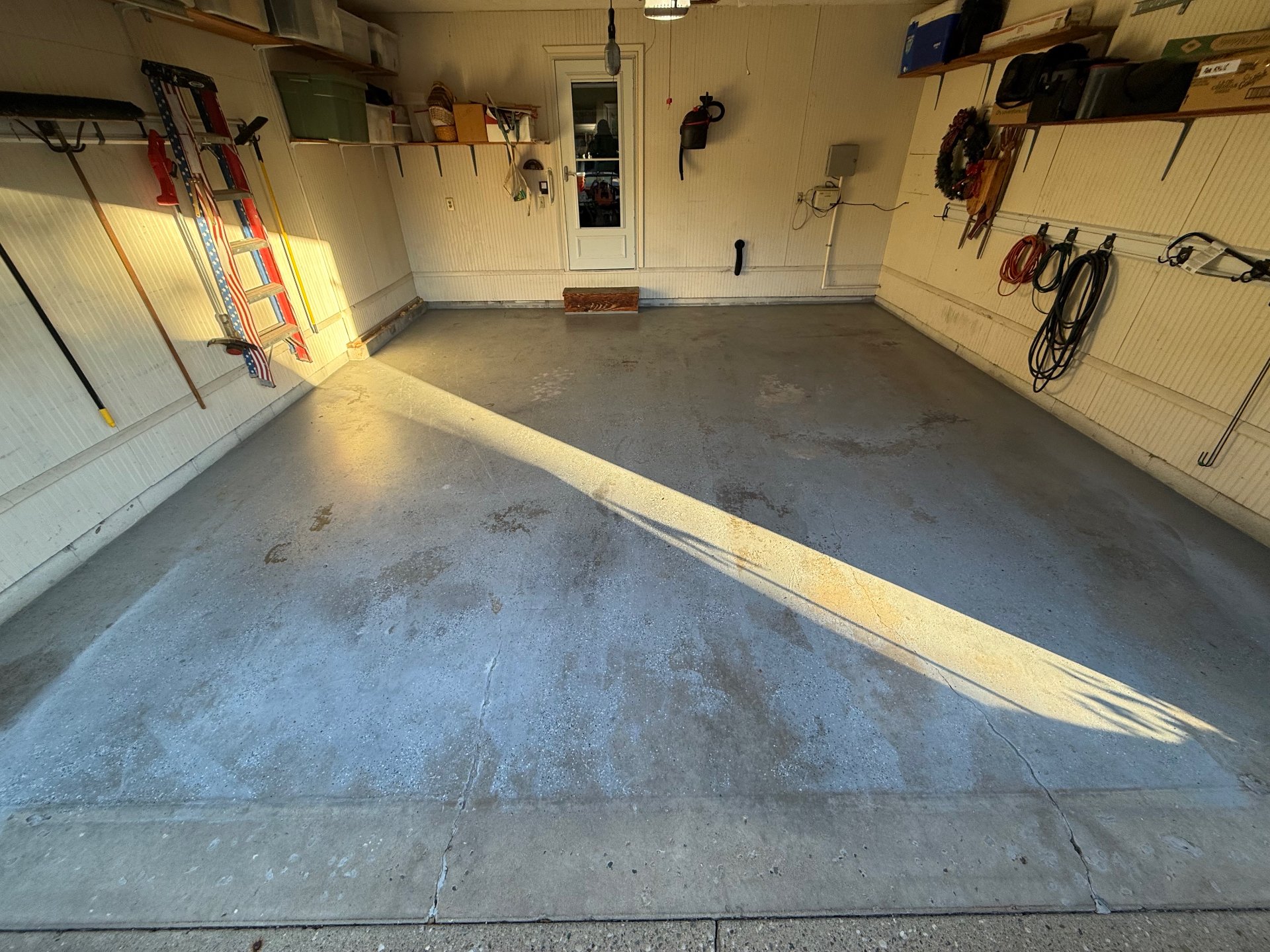 Cracked, stained concrete garage slab before coating, inside the garage