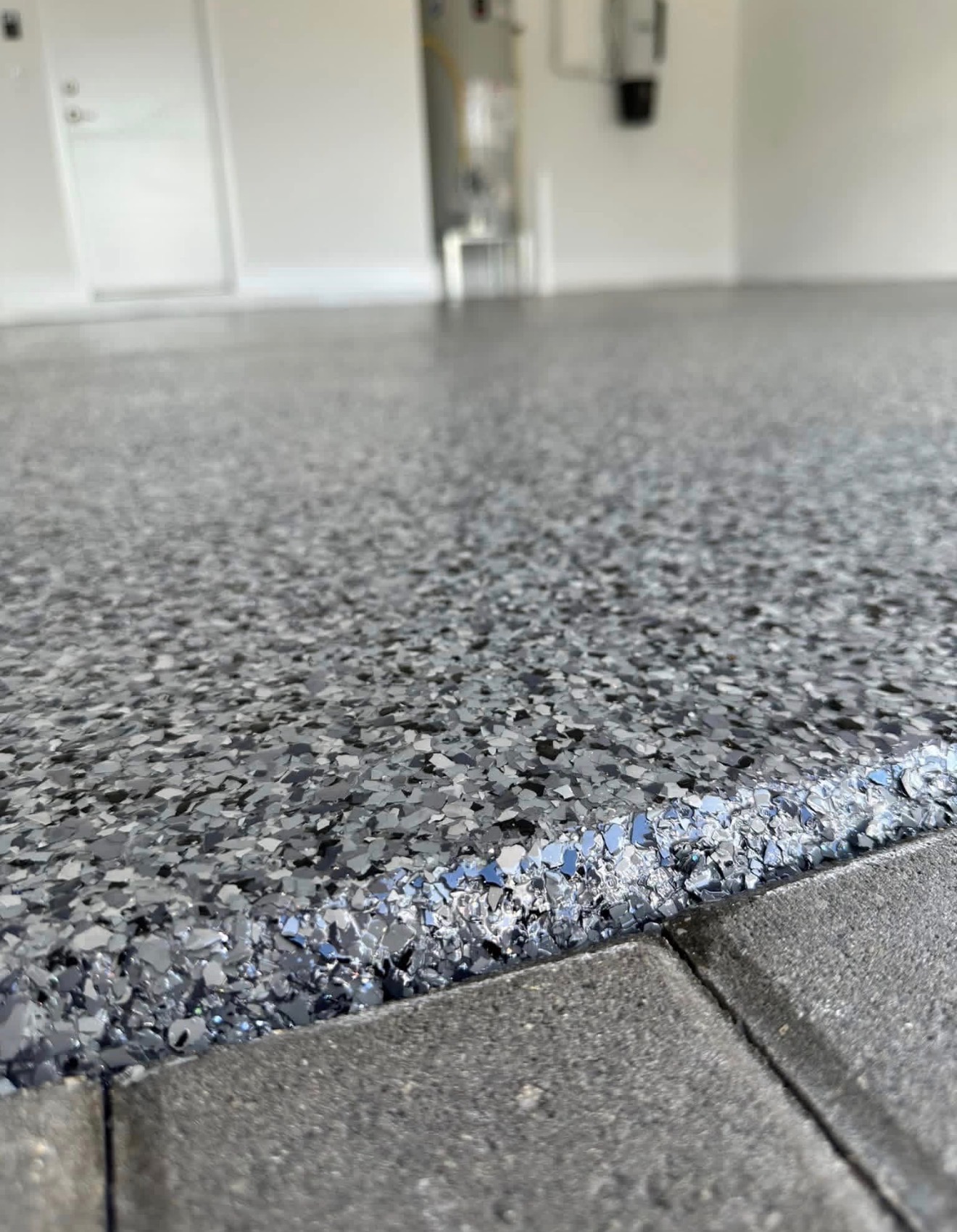 Detailed edge of a gray flake epoxy garage floor