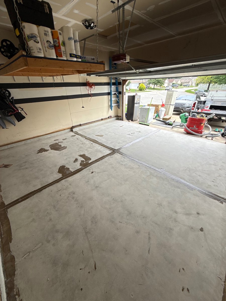 Concrete garage floor before coating with patched joints, seen from the doorway